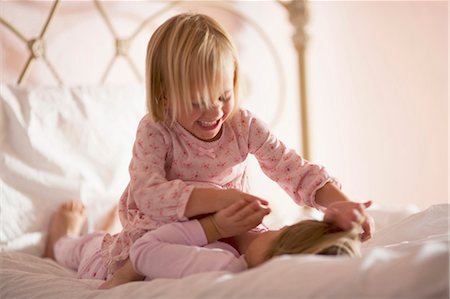Two girls playing on bed Stock Photo - Premium Royalty-Free, Code: 640-03260195