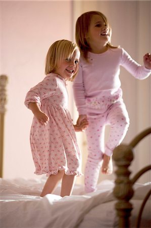 Two girls playing on bed Stock Photo - Premium Royalty-Free, Code: 640-03260192