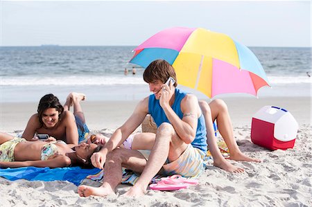 sunning - Man with cell phone on beach Foto de stock - Sin royalties Premium, Código: 640-03260548