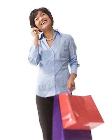 Woman holding shopping bags and talking on cell phone Stock Photo - Premium Royalty-Free, Code: 640-03260690