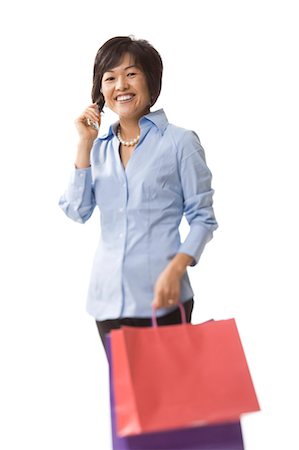 Woman holding shopping bags and talking on cell phone Stock Photo - Premium Royalty-Free, Code: 640-03260691