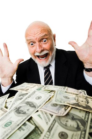 Closeup of businessman looking at pile of money Stock Photo - Premium Royalty-Free, Code: 640-03261065