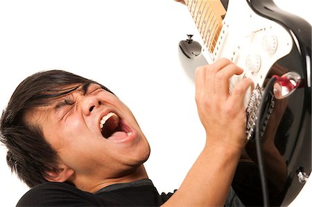 rock face - Portrait of young man playing electric guitar Foto de stock - Sin royalties Premium, Código: 640-03261146