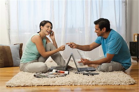 Man and woman on carpet with laptops Stock Photo - Premium Royalty-Free, Code: 640-03261443