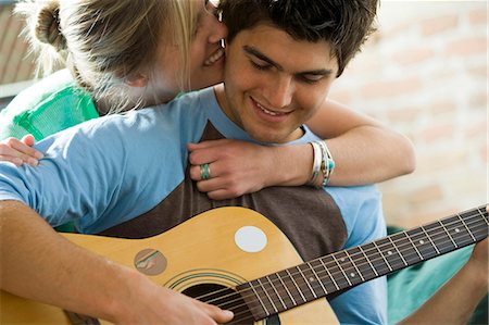 simsearch:640-03259856,k - Man playing guitar with woman behind him Stock Photo - Premium Royalty-Free, Code: 640-03261472