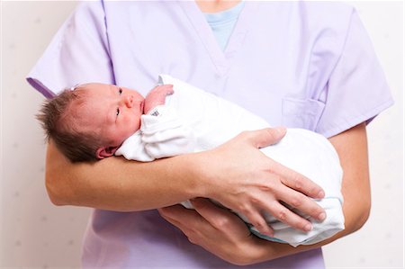 simsearch:640-03261677,k - Nurse holding newborn baby Foto de stock - Royalty Free Premium, Número: 640-03261677