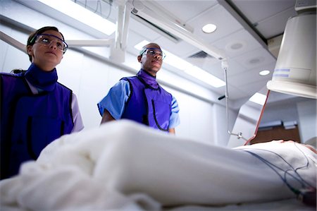 person in hospital bed overhead - Aerial of woman undergoing x-ray in lab Stock Photo - Premium Royalty-Free, Code: 640-03261700