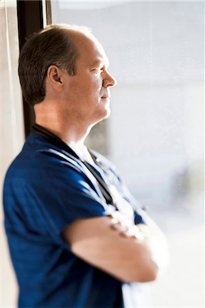 simsearch:640-03261804,k - Male doctor looking through window Stock Photo - Premium Royalty-Free, Code: 640-03261761