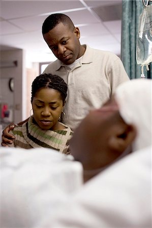 sick african american - Family watching boy in hospital bed with head bandages Stock Photo - Premium Royalty-Free, Code: 640-03261821