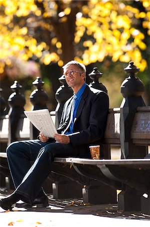 Businessman on wooden bench outdoors with newspaper Stock Photo - Premium Royalty-Free, Code: 640-03261914