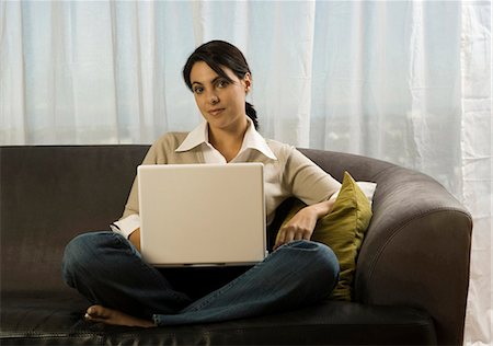 seated cross leg home chair - Woman on sofa with laptop Stock Photo - Premium Royalty-Free, Code: 640-03262010