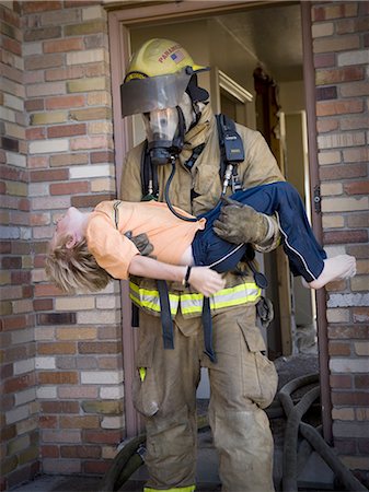 firefighter saving boy - Fire fighter rescuing child Stock Photo - Premium Royalty-Free, Code: 640-03262136