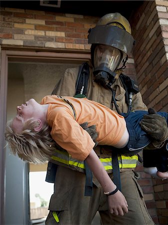 Fire fighter rescuing child Stock Photo - Premium Royalty-Free, Code: 640-03262137