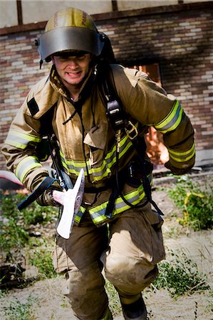 firefighter outdoors - Firefighter with axe running from blaze Foto de stock - Sin royalties Premium, Código: 640-03262190