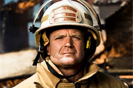 firefighter outdoors - Portrait of a firefighter with fire in background Foto de stock - Sin royalties Premium, Código: 640-03262211