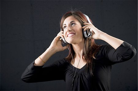 simsearch:640-02773489,k - Woman with headphones smiling Fotografie stock - Premium Royalty-Free, Codice: 640-03262342