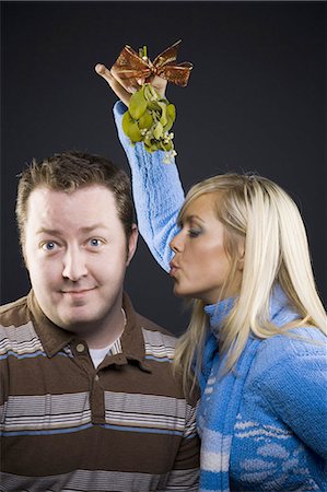 Woman with mistletoe giving man kiss Foto de stock - Sin royalties Premium, Código: 640-03262422