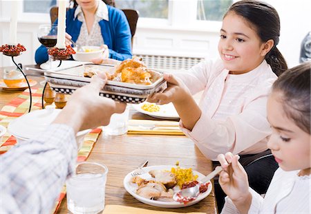 Girl holding food at dinner table Stock Photo - Premium Royalty-Free, Code: 640-03262692