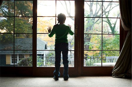 Jeune fille regardant à travers une grande fenêtre Photographie de stock - Premium Libres de Droits, Code: 640-03262725