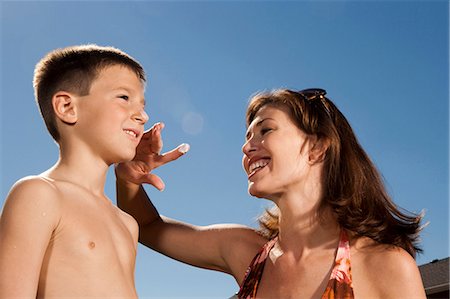 Woman applying sunscreen lotion to boy's face Stock Photo - Premium Royalty-Free, Code: 640-03262789