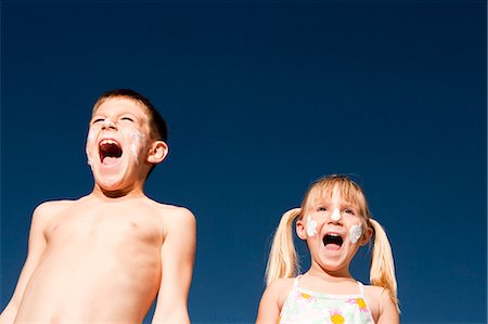 shout low angle - Boy and girl with sunscreen shouting Stock Photo - Premium Royalty-Free, Code: 640-03262794