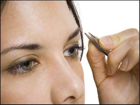 Closeup of woman tweezing eyebrows Stock Photo - Premium Royalty-Free, Code: 640-03262944