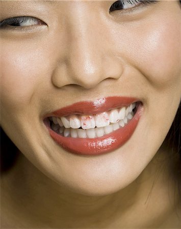 Gros plan de femme souriant avec rouge à lèvres sur les dents Photographie de stock - Premium Libres de Droits, Code: 640-03262952