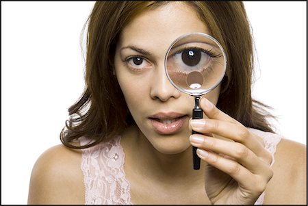 Closeup of woman looking through magnifying glass Stock Photo - Premium Royalty-Free, Code: 640-03263030