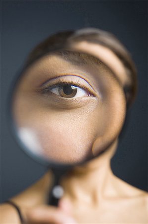 Closeup of woman holding magnifying glass to eye Foto de stock - Sin royalties Premium, Código: 640-03263149