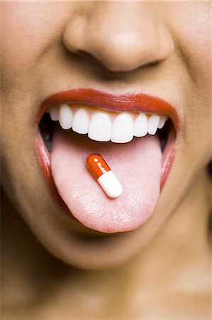 Woman wearing red lipstick with a pill on tongue Foto de stock - Sin royalties Premium, Código: 640-03263173