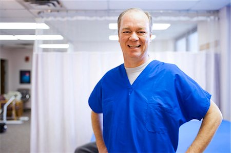 simsearch:640-03263228,k - Male health care worker standing with crossed arms smiling Stock Photo - Premium Royalty-Free, Code: 640-03263230