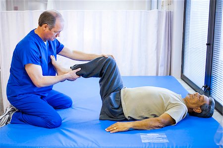 Physical therapist holding leg of a patient Stock Photo - Premium Royalty-Free, Code: 640-03263241