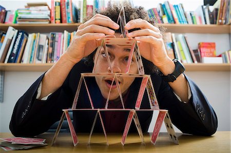 Homme faisant une pyramide de cartes à jouer Photographie de stock - Premium Libres de Droits, Code: 640-03263847