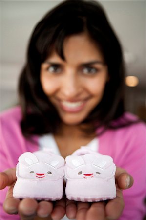 Woman holding baby shoes Stock Photo - Premium Royalty-Free, Code: 640-03281695