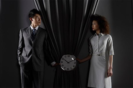 a business man and a business woman holding a clock Stock Photo - Premium Royalty-Free, Code: 642-01734001