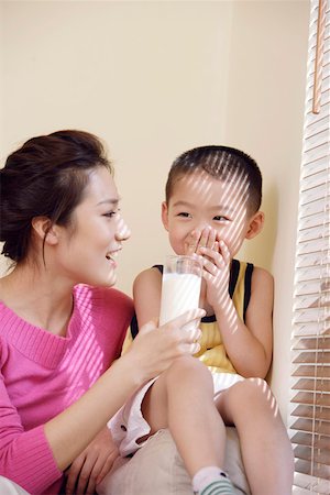 feeding asian family - Mother giving glass of milk to son Stock Photo - Premium Royalty-Free, Code: 642-01734201