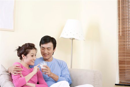 photo of a woman feeding her husband food - Husband feeding glass of milk to wife and smiling Stock Photo - Premium Royalty-Free, Code: 642-01734211