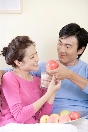 photo of a woman feeding her husband food - Young man with young woman holding apple Stock Photo - Premium Royalty-Free, Code: 642-01734212