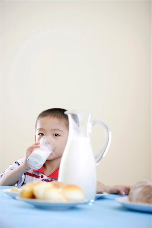 simsearch:642-01734328,k - Boy sitting at breakfast table and drinking milk Stock Photo - Premium Royalty-Free, Code: 642-01734260