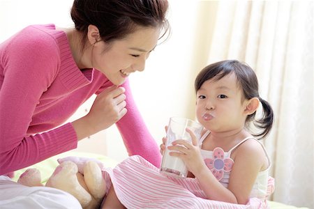 puckered lips profile - Daughter sitting with mother and having a glass of milk Stock Photo - Premium Royalty-Free, Code: 642-01734324