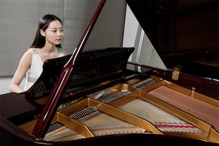 piano performance dress - Young woman playing grand piano Stock Photo - Premium Royalty-Free, Code: 642-01734433