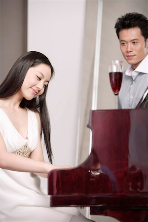 piano performance dress - Man looking at woman playing piano Stock Photo - Premium Royalty-Free, Code: 642-01734452