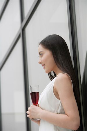 simsearch:642-01737214,k - Young woman with wineglass standing by glass wall Stock Photo - Premium Royalty-Free, Code: 642-01734475