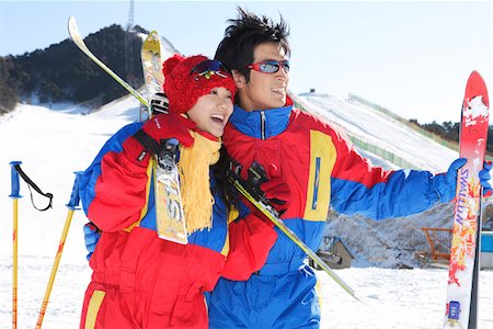 smiling chinese man with cap - Young couple holding skis and ski poles, smiling Stock Photo - Premium Royalty-Free, Code: 642-01734548