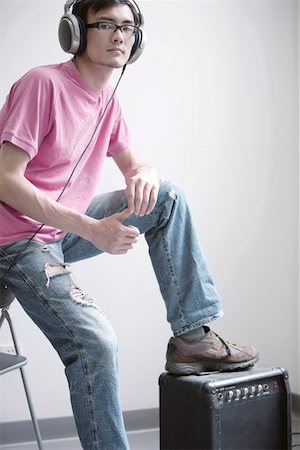 Young man enjoying music, standing on voice box Stock Photo - Premium Royalty-Free, Code: 642-01734654