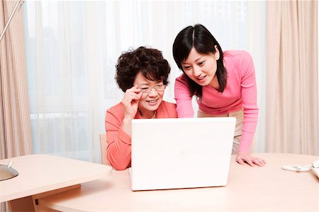 daughter helping elderly parent - Mother and daughter playing with laptop at desk Stock Photo - Premium Royalty-Free, Code: 642-01734672