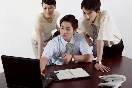 simsearch:642-01734721,k - Businessmen and a businesswoman looking at a laptop Foto de stock - Royalty Free Premium, Número: 642-01734720