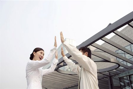 Businesswoman giving high-five to businessman, smiling Stock Photo - Premium Royalty-Free, Code: 642-01734807