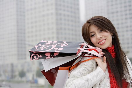 simsearch:642-01734897,k - Portrait of a young woman smiling and holding shopping bags Stock Photo - Premium Royalty-Free, Code: 642-01734920