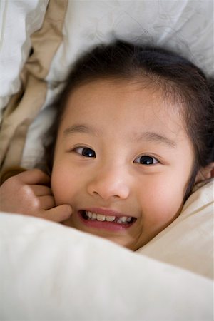 simsearch:642-01735641,k - Gros plan d'une jeune fille souriante sur lit Photographie de stock - Premium Libres de Droits, Code: 642-01735030